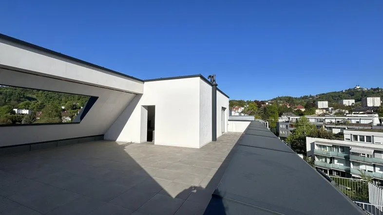 Große Dachterrasse mit moderner Architektur und weitem Blick über die Umgebung.
