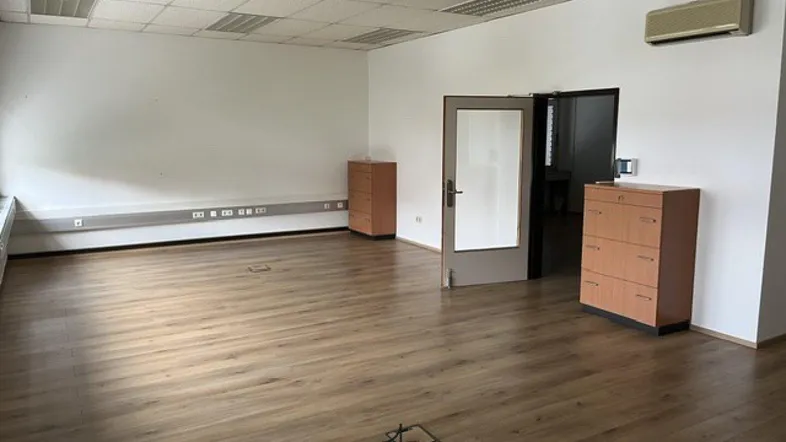 Geräumiges Büro mit Laminatboden, abgehängter Decke und Klimaanlage, bereit zur individuellen Gestaltung.