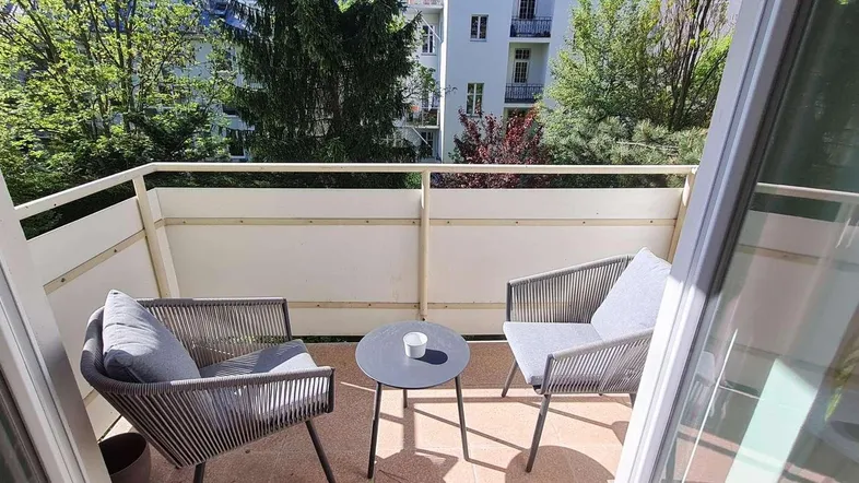 Gemütlicher Balkon mit modernen Sitzgelegenheiten und einem angenehmen Blick ins Grüne.
