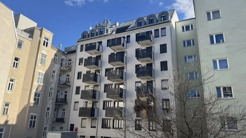 Ansicht eines modernen Wohngebäudes mit zahlreichen Balkonen und klarer Architektur.