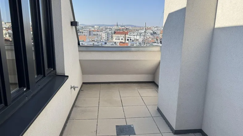 Kleine geflieste Terrasse mit weitem Blick über die Dächer der Stadt.