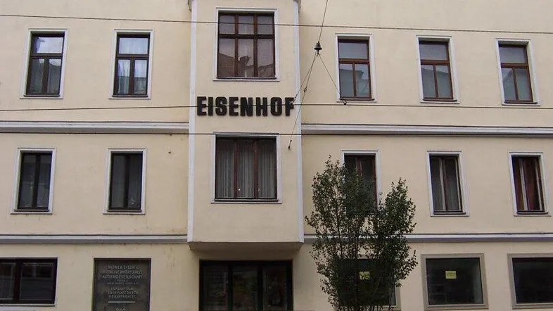 Historisches Gebäude mit klassischer Fassade und Geschäftsflächen im Erdgeschoss in urbaner Umgebung.