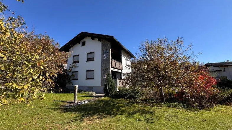 Großzügiger Gartenbereich mit Rasenfläche und altem Baumbestand vor dem Wohnhaus.