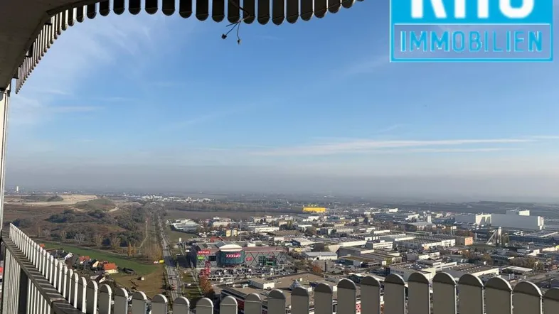 Weitläufiger Blick über die Stadt und umliegende Landschaft von einem hohen Balkon.