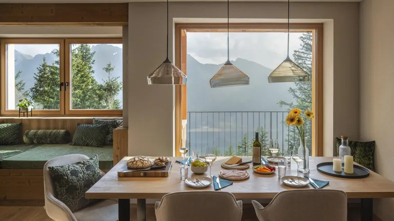 Heller Essbereich mit großem Fenster, Bergblick und gemütlicher Sitzbank.
