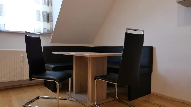 Gemütlicher Essbereich mit Eckbank, Holztisch und modernen Stühlen unter Dachschräge.