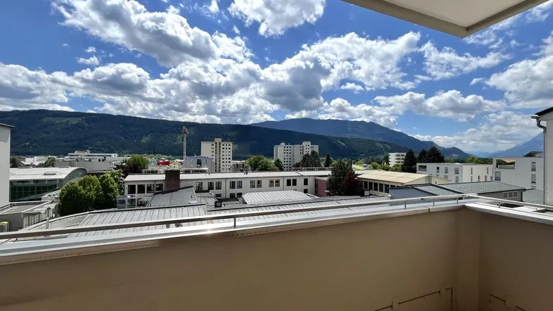 Geräumiger Balkon mit weitem Blick über die Stadt und die umliegenden Berge.