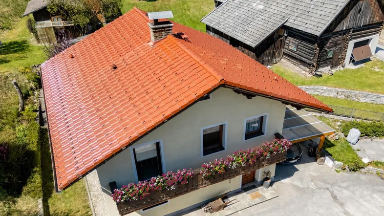 Luftaufnahme des Hauses mit rotem Ziegeldach und umliegender grüner Landschaft.