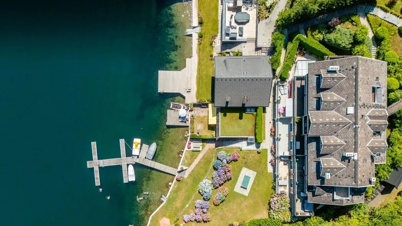 Senkrechte Luftaufnahme des Grundstücks am See mit detaillierter Ansicht der Gebäude und Gärten.
