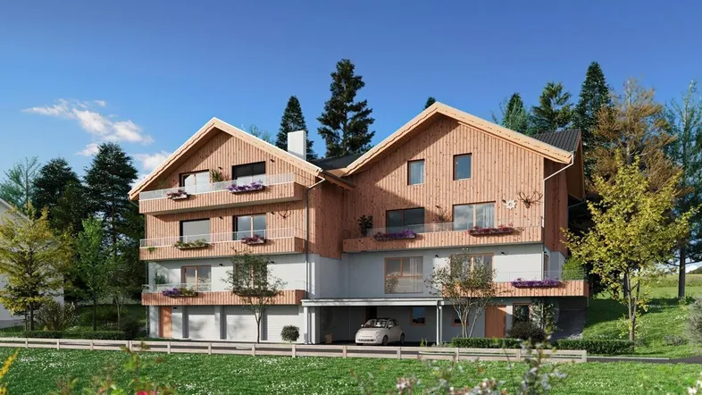 Moderne Chalet-Architektur mit Holzfassade, Balkonen und Carport in grüner Berglandschaft.