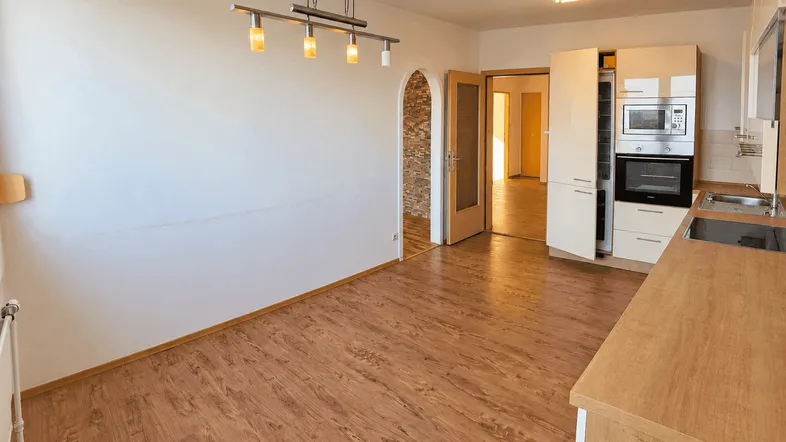 Heller offener Bereich mit integrierter Küche, Laminatboden und Essplatz für geselliges Beisammensein.