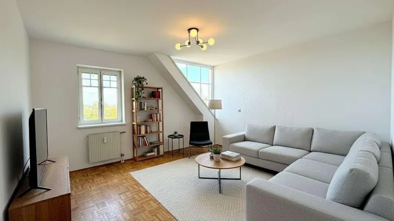Helles Wohnzimmer mit Parkettboden, Dachschrägen und moderner Einrichtung, ideal zum Entspannen.