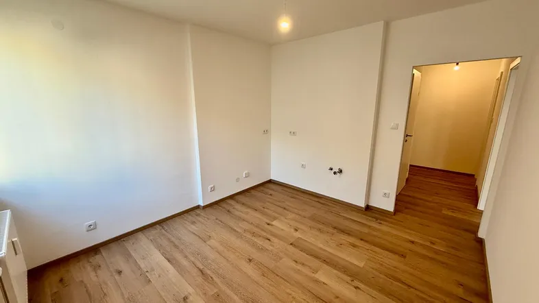 Heller Raum mit neuem Laminatboden und weißen Wänden, bereit zum Einzug.