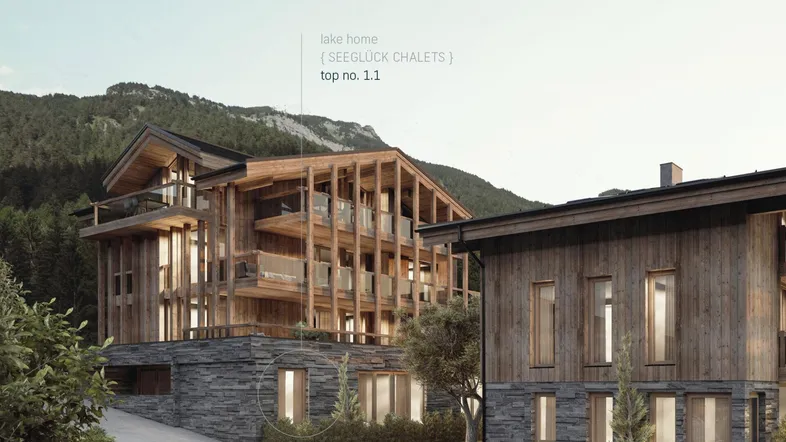 Moderne Holzarchitektur mit Steinfassade und Balkonen vor einer Bergkulisse.