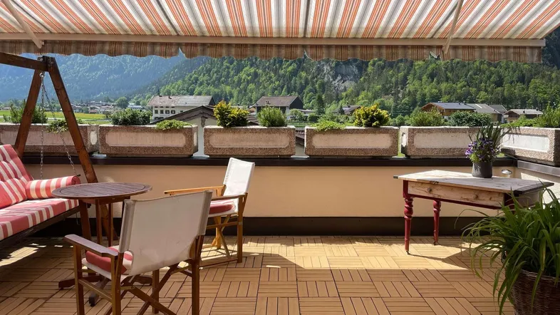 Große Terrasse mit Markise, Sitzgelegenheiten und herrlichem Bergblick.