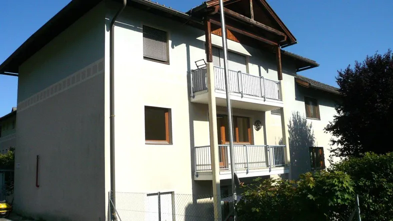 Mehrfamilienhaus mit mehreren Balkonen und einer gepflegten Fassade in sonniger Lage.