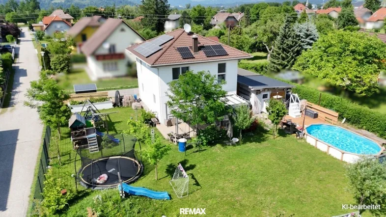 Luftaufnahme des Hauses mit großem Garten, Spielplatz und oberirdischem Pool.