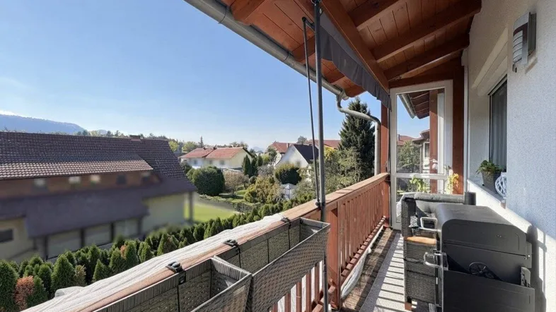 Geräumiger Balkon mit Holzdach, Grill und Sitzgelegenheiten, bietet einen schönen Blick ins Grüne.