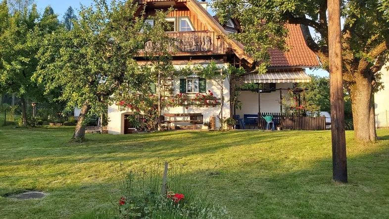 Charmantes Landhaus mit traditioneller Holzfassade und großem, gepflegtem Garten in sonniger Lage.