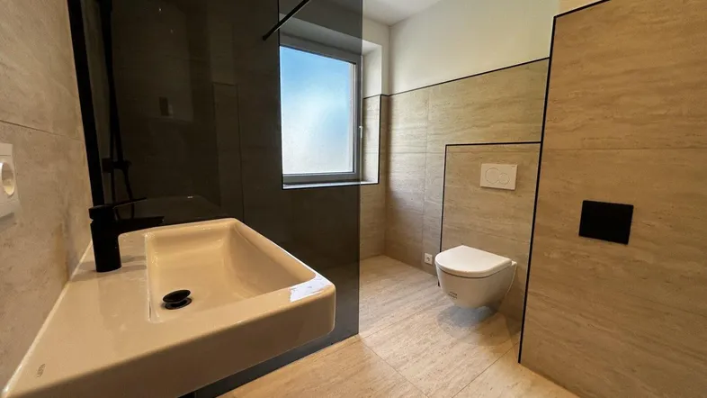 Modernes Badezimmer mit ebenerdiger Dusche, Hänge-WC und Fenster für natürliches Licht.