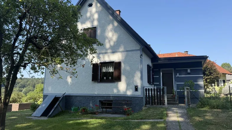 Traditionelles Einfamilienhaus mit Satteldach und Vorgarten in ländlicher Umgebung.