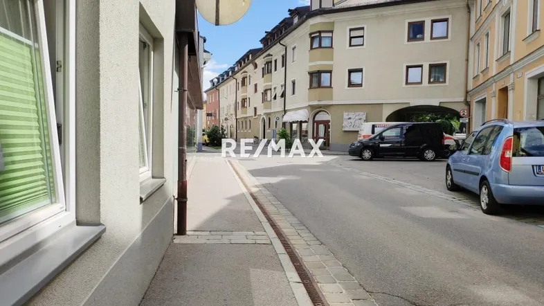 Blick auf die Straße und die umliegenden Gebäude in einer städtischen Umgebung mit geparkten Autos.