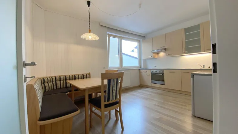 Helle Wohnküche mit Einbauküche, Essbereich und Laminatboden, ideal für gemütliche Mahlzeiten.