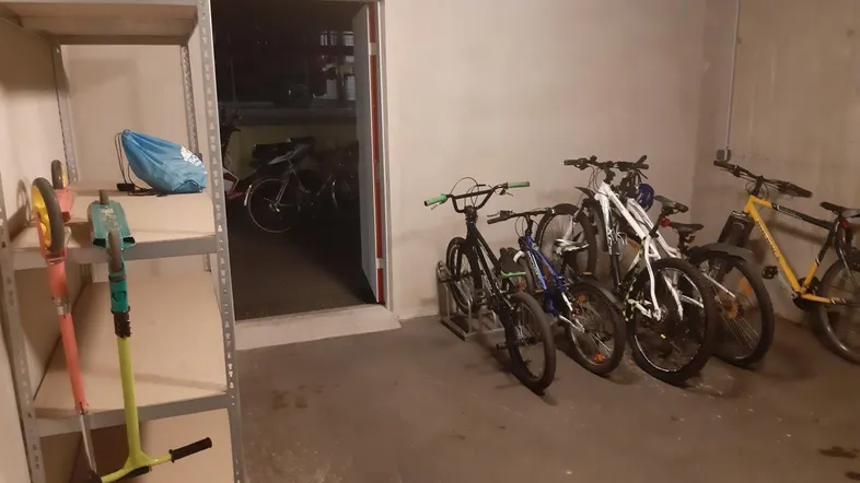 Geräumiger Fahrradraum mit mehreren Fahrrädern und einem praktischen Regal für Werkzeuge.