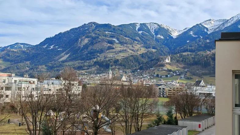 Panoramablick auf die umliegende Berglandschaft und eine charmante Kleinstadt.