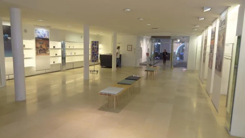 Geräumiger Verkaufsraum mit hellen Fliesenböden, weißen Säulen und modernen Präsentationsflächen.