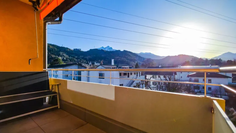 Geräumiger Balkon mit Fliesenboden und weitem Blick auf die umliegende Berglandschaft.