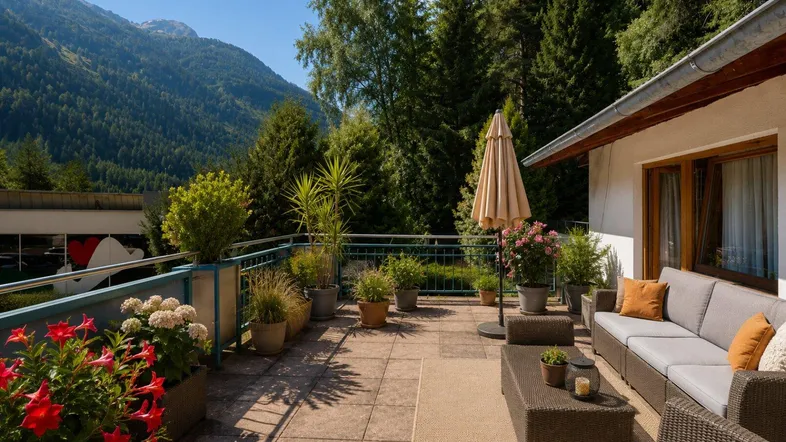 Große geflieste Terrasse mit bequemen Sitzmöbeln, Pflanzen und herrlichem Bergblick.