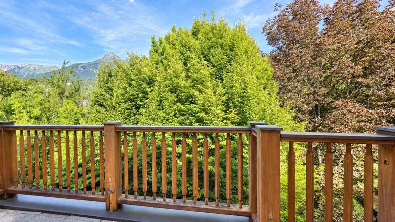 Geräumige Terrasse mit Holzbalkon und weitem Blick auf die umliegende Berglandschaft.