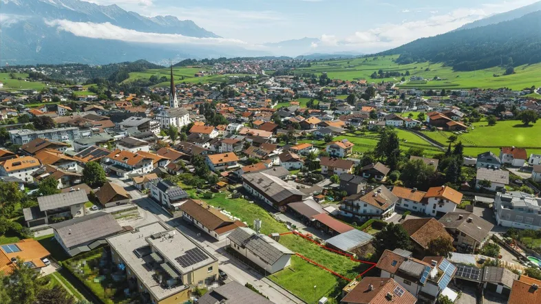 Luftaufnahme eines Grundstücks in einer ländlichen Gemeinde mit Bergblick.