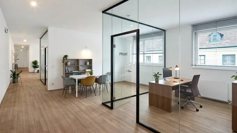Modernes Büro mit Glaswänden, Holzboden und natürlichem Licht, ideal für produktives Arbeiten.