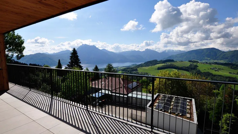 Geräumiger Balkon mit Fliesenboden und atemberaubendem Blick auf Berge und See.