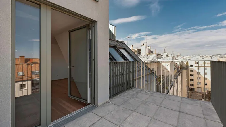 Geräumiger Balkon mit Fliesenboden und weitem Blick über die Stadt, verbunden mit einem Innenraum.