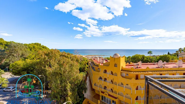 Panoramablick vom Balkon auf das Meer, die Küste und die umliegende Bebauung unter blauem Himmel.