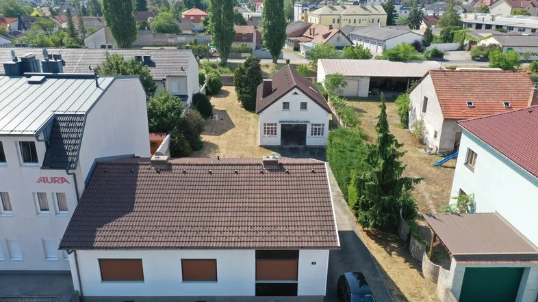 Luftaufnahme des Anwesens mit mehreren Gebäuden und der umliegenden Nachbarschaft.