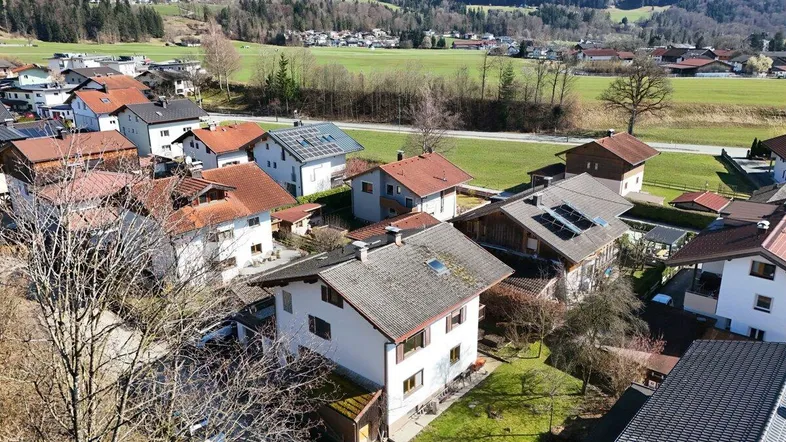 Weitläufige Luftaufnahme der Wohnsiedlung mit Häusern und grüner Landschaft im Hintergrund.