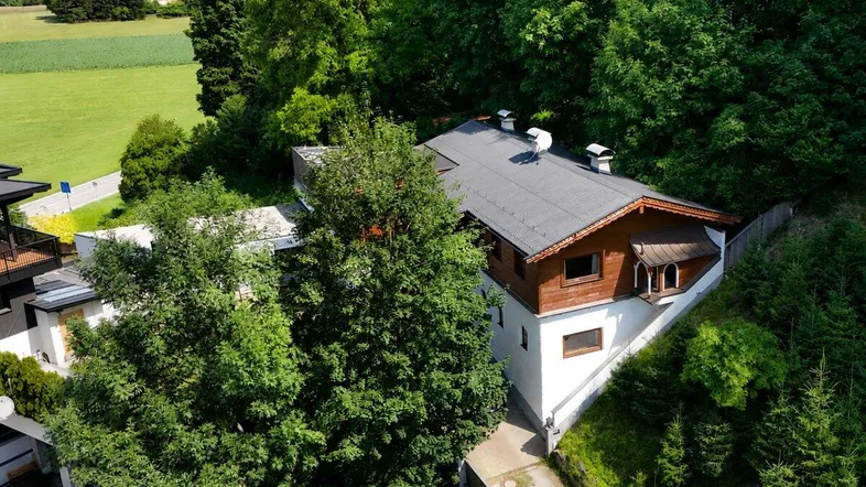 Luftaufnahme des Anwesens, eingebettet in grüne Natur mit Wald und Feldern.