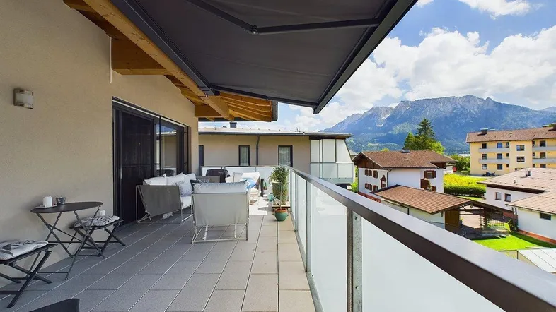 Geräumige Terrasse mit bequemen Loungemöbeln, Sonnenschutz und beeindruckendem Bergblick.