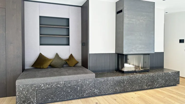 Moderner Wohnbereich mit integrierter Sitzbank, Kamin und Holzboden in ansprechendem Design.