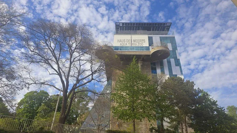 Ansicht des Haus des Meeres mit seiner markanten Kombination aus historischem Bunker und moderner Glasfassade unter blauem Himmel.