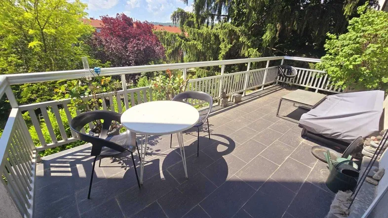 Geräumige Terrasse mit Sitzgelegenheiten und Blick ins Grüne, ideal zum Entspannen im Freien.