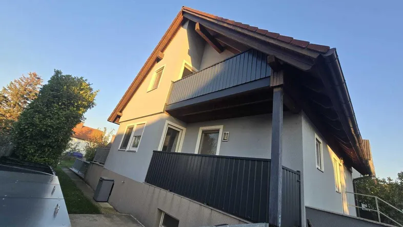 Modernes Einfamilienhaus mit Balkon und Satteldach in ruhiger Wohngegend.