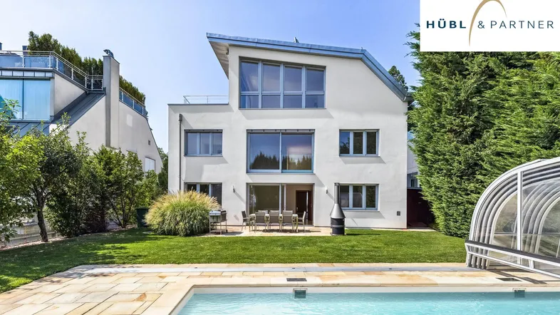 Modernes Haus mit Garten, Pool und Terrasse, umgeben von Grün und mit viel Sonnenlicht.
