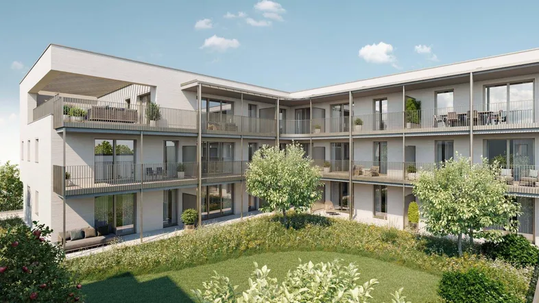 Moderne Wohnanlage mit mehreren Balkonen und Terrassen, umgeben von einem begrünten Innenhof.