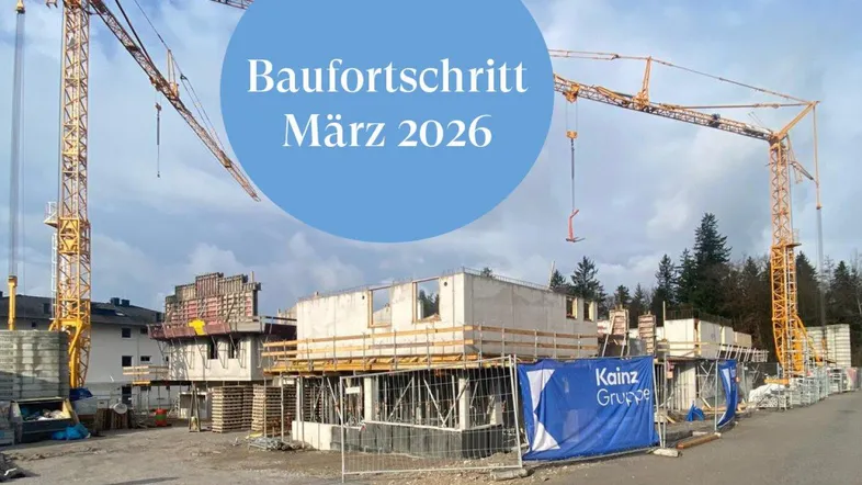 Baustelle mit mehreren im Bau befindlichen Gebäuden und hohen Kränen unter bewölktem Himmel.