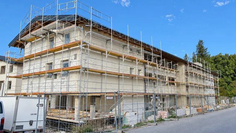 Gebäude im Bau mit Gerüst, zeigt den Baufortschritt im September 2026 unter blauem Himmel.